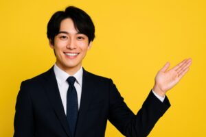 スーツ姿で右手を上げて案内する若い男性