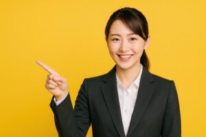 黄色背景で指をさして案内するスーツ姿の女性