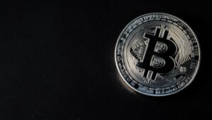 黒い背景に浮かび上がるシルバーのビットコイン