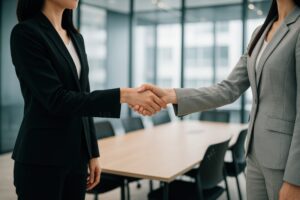 会議室で握手するスーツ姿のビジネスウーマン