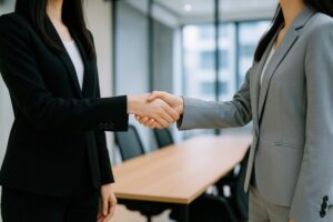 明るい会議室で握手するビジネスウーマン