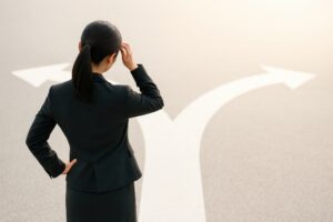 将来の選択に迷うビジネスウーマンと分かれ道