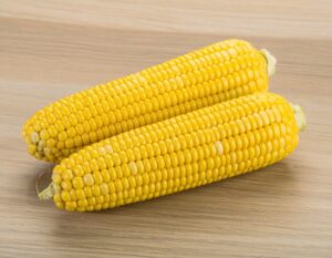 皮をむいた2本のトウモロコシを木製テーブルの上に置いた