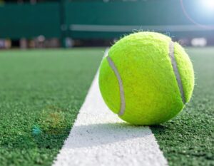 白線の上のテニスボールと晴天