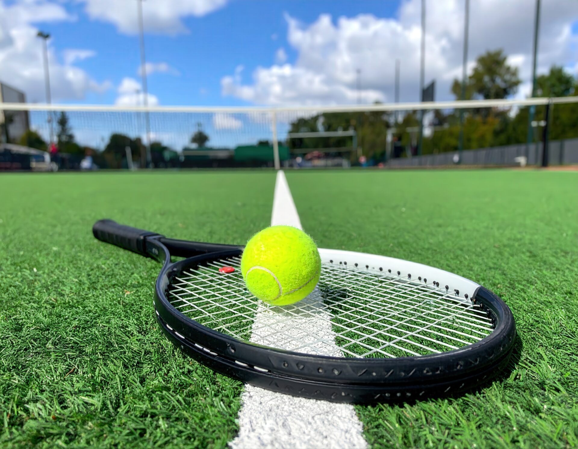 人工芝コートに置かれたラケットとボール