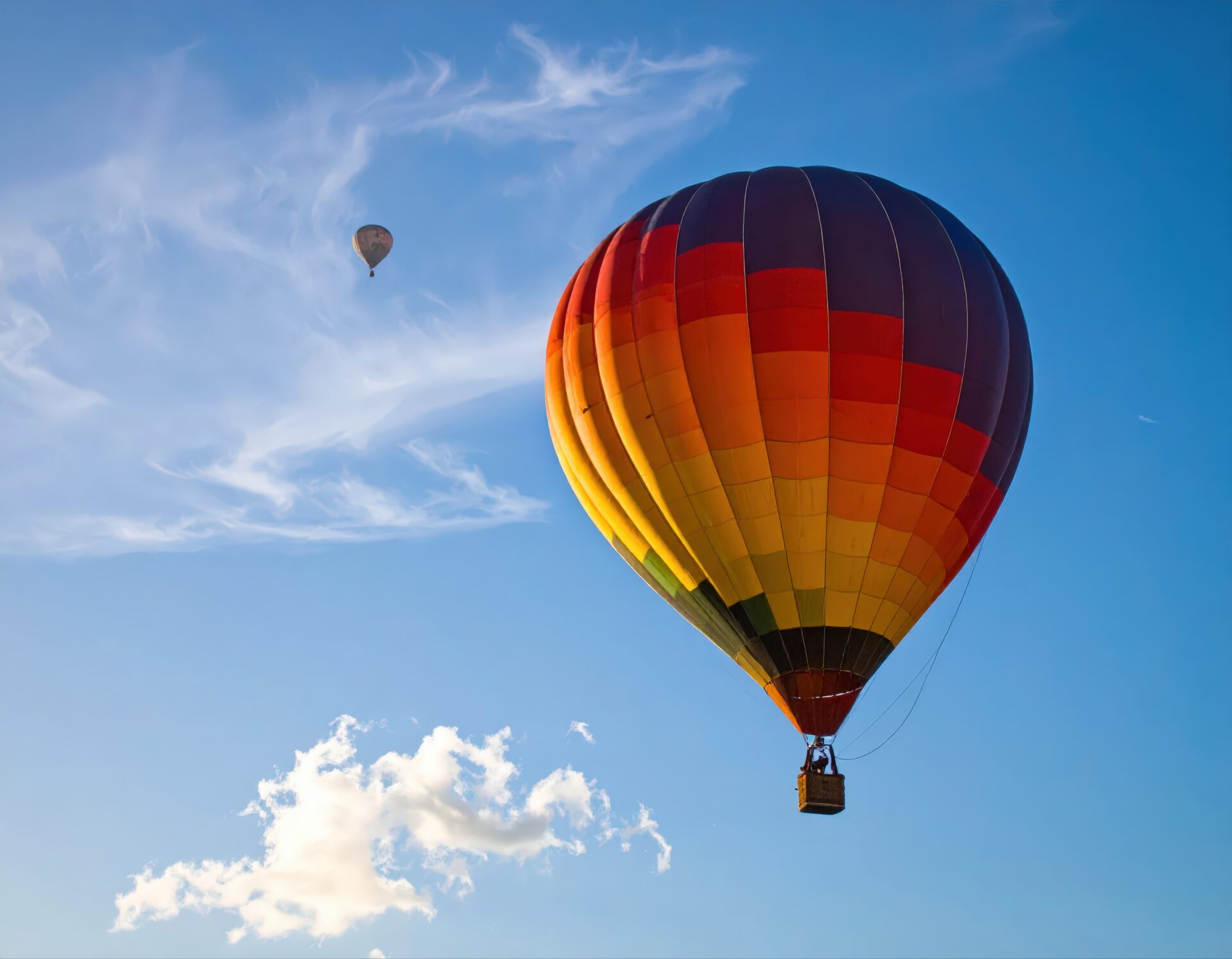 青空に浮かぶオレンジと黄色の熱気球