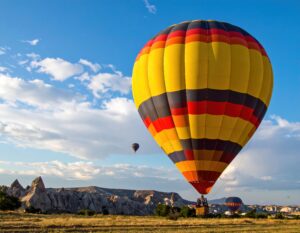 岩山と青空に浮かぶ黄色と赤の熱気球