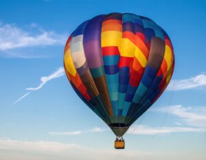 青空に映える青と赤のカラフルな熱気球