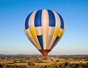 草原の上に浮かぶ青と黄色の熱気球