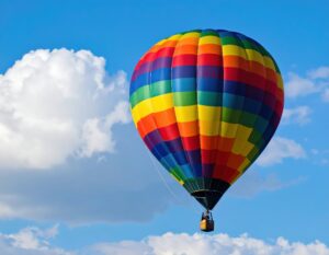 青空と雲に映える虹色の熱気球