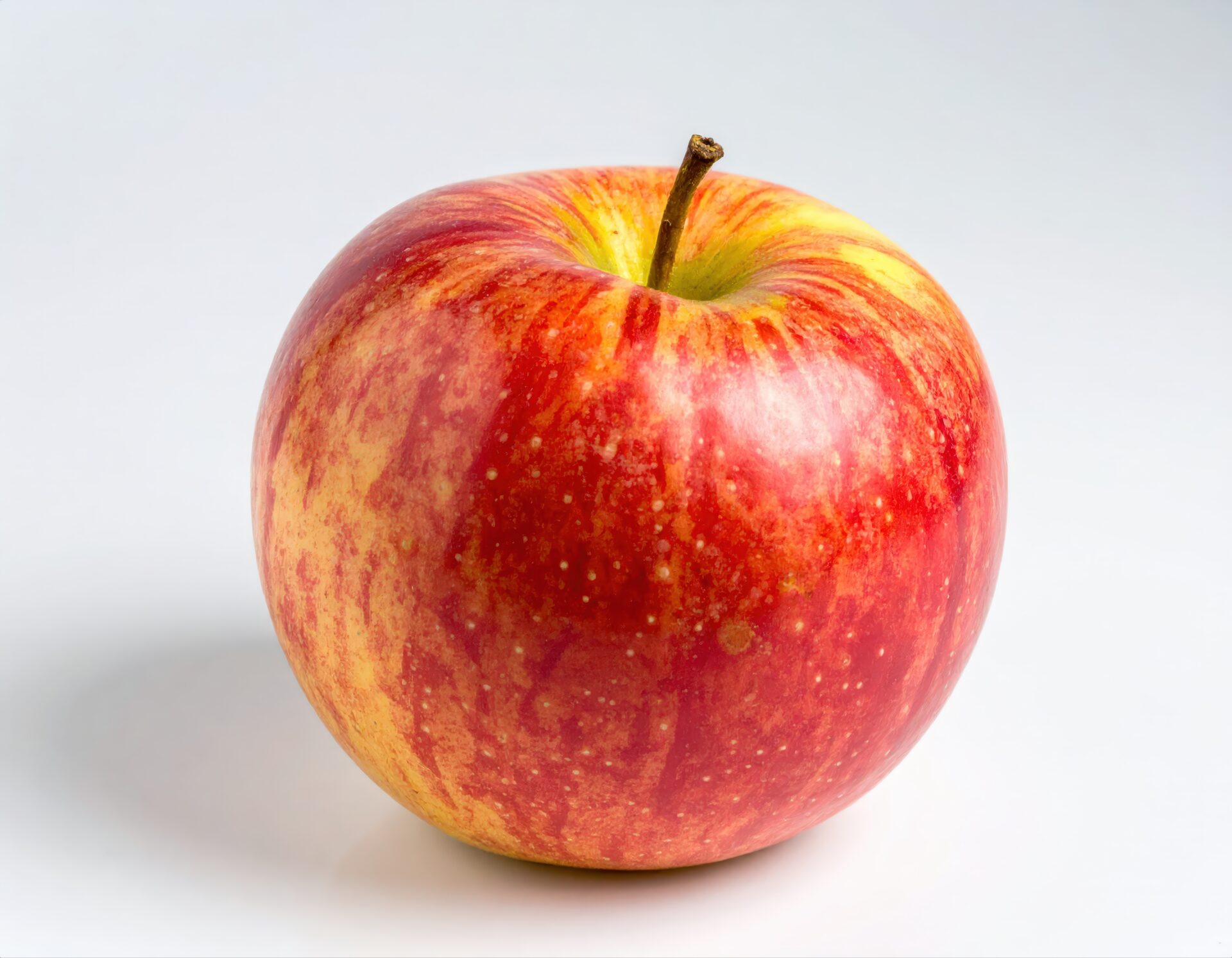 白背景に置かれた赤と黄色のリンゴ