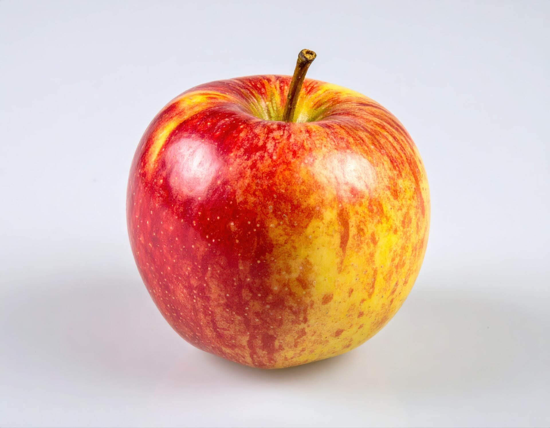 白背景に置かれた新鮮な赤と黄色のリンゴ