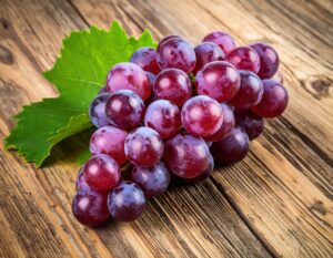 木製テーブルに置かれた房付きの紫ブドウ