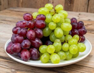 皿に盛られた紫と緑のブドウ