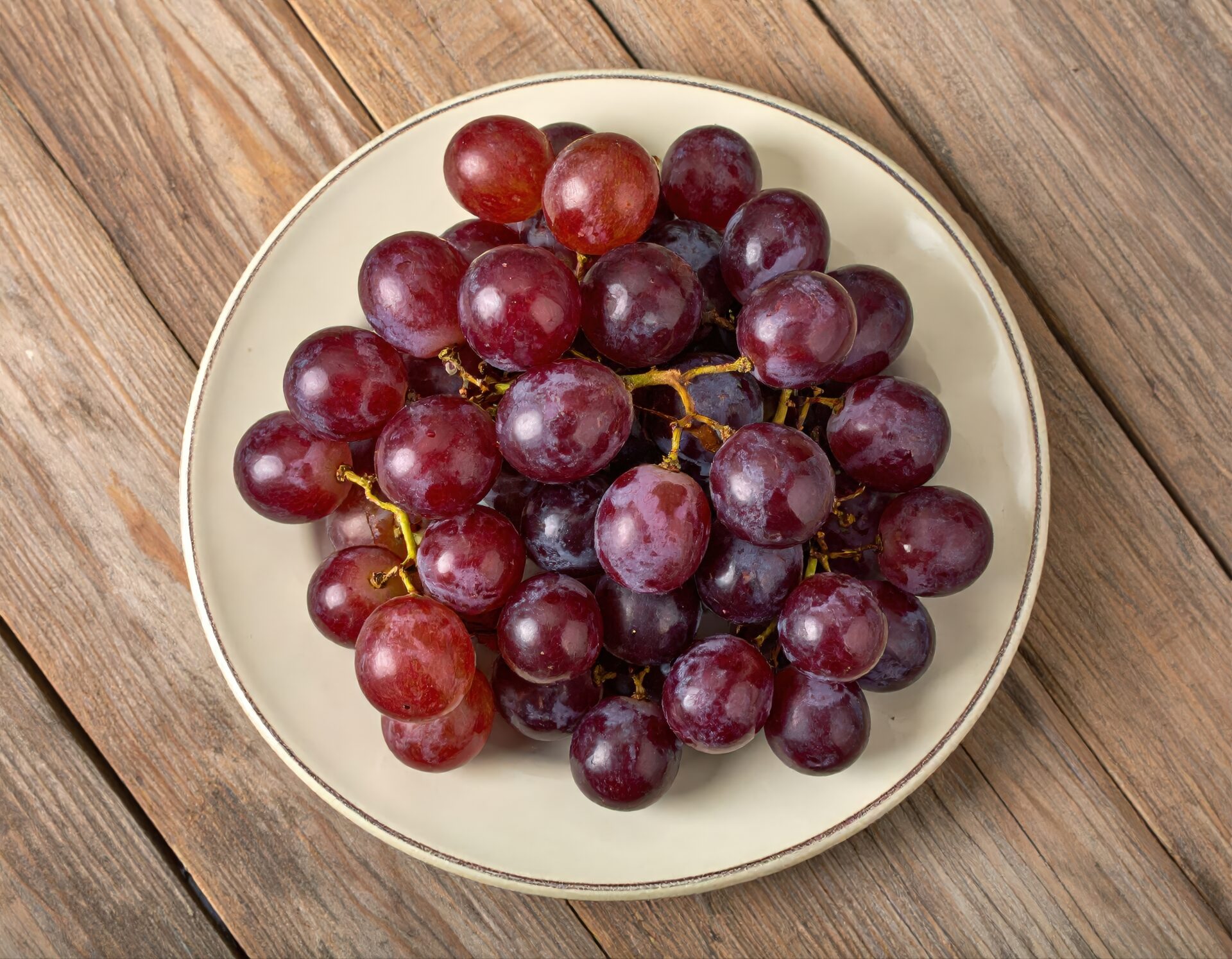 白い皿に盛られた赤いブドウ