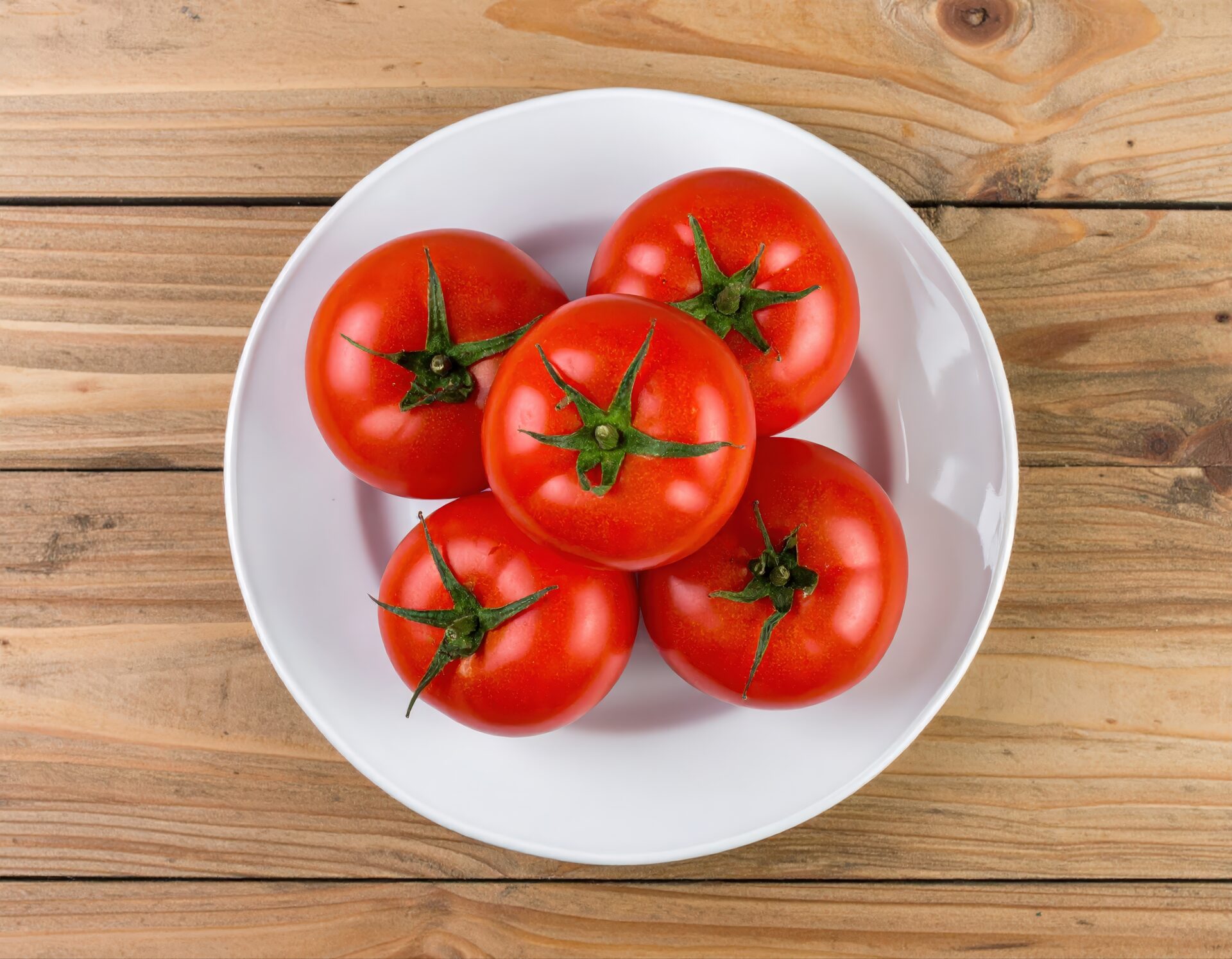 白い皿に盛られた5個のトマト