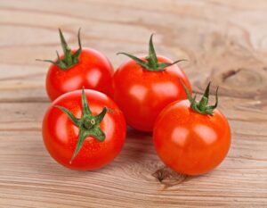 木のテーブルに並べられた4個のトマト