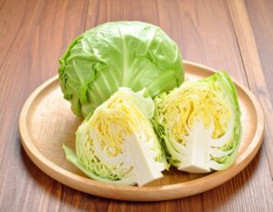 木製プレートに丸ごとのキャベツとカットキャベツ