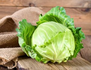 麻布の横に置かれた丸ごとのキャベツ