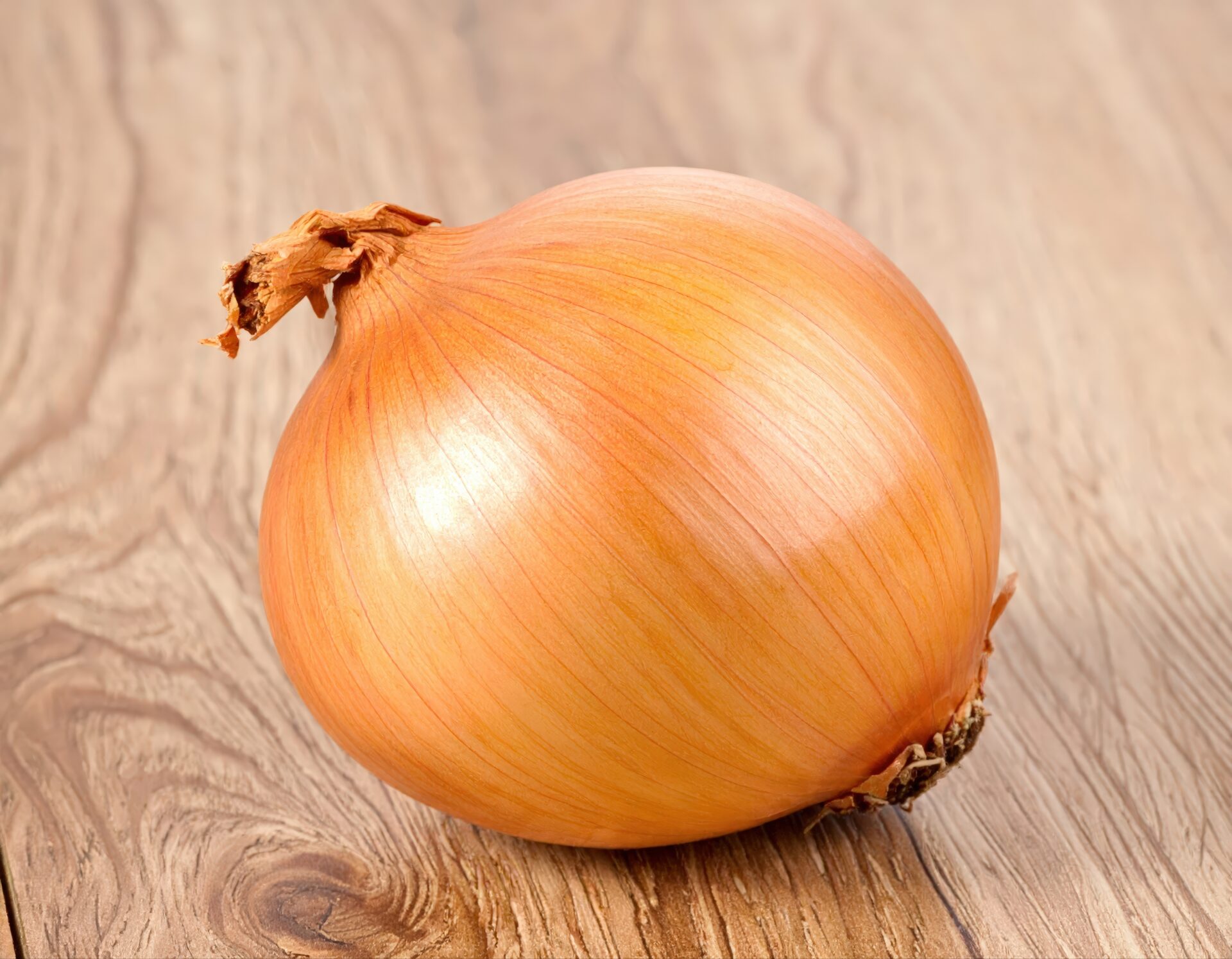 木目のテーブルに置かれた玉ねぎ