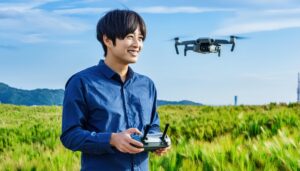 緑の草原でドローンを操作する男性