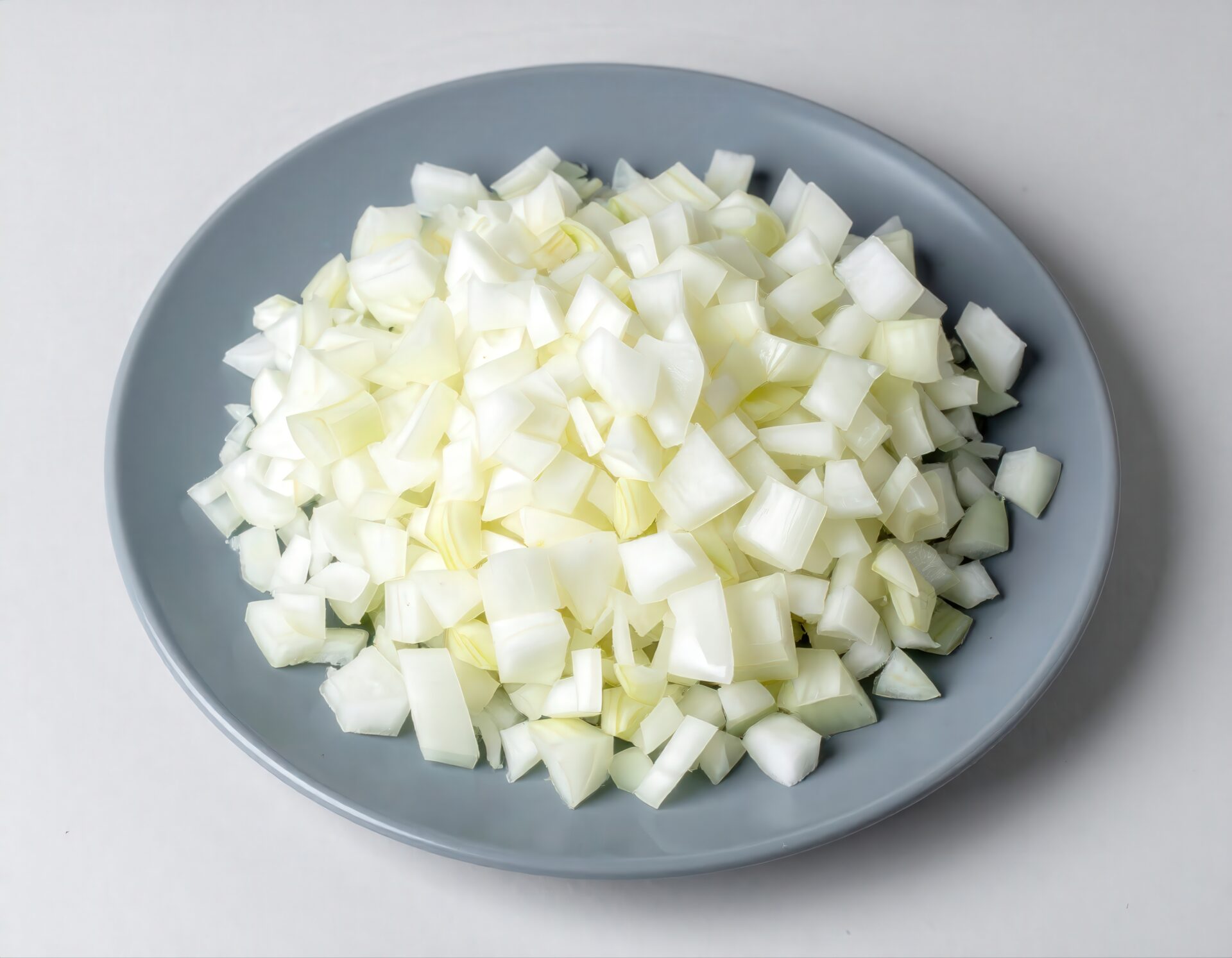 グレーの皿に盛られたみじん切り玉ねぎ