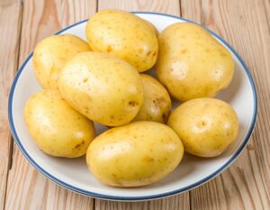 白い皿に盛られた複数の皮付きジャガイモ
