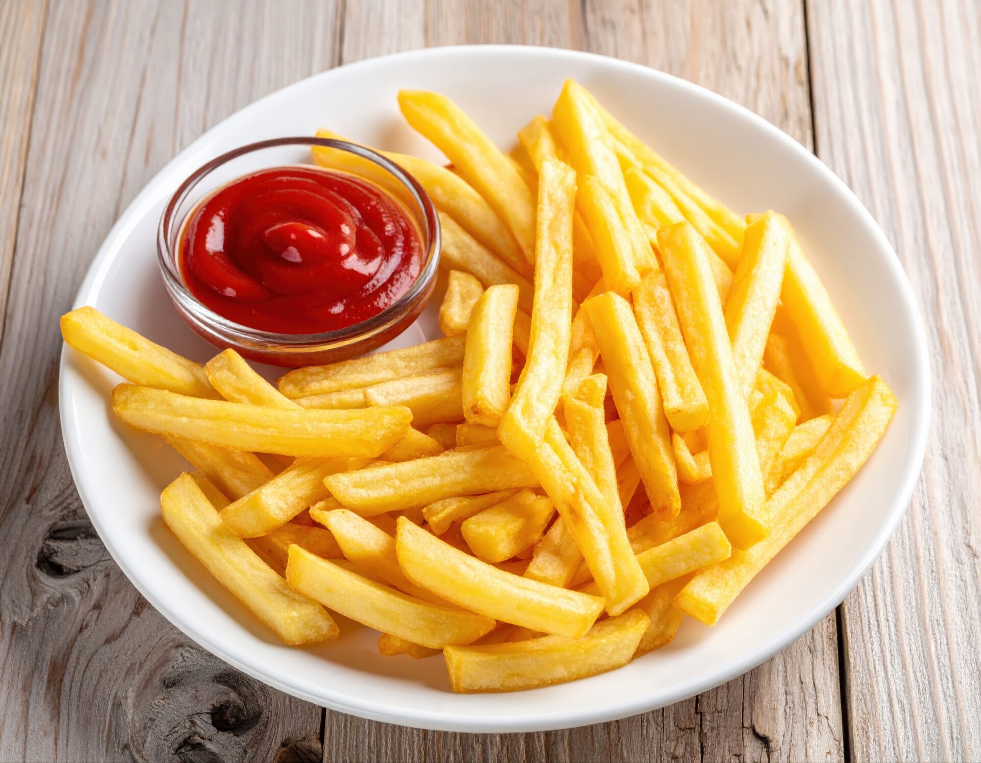 白い皿に盛られたフライドポテトとガラスの器のケチャップ