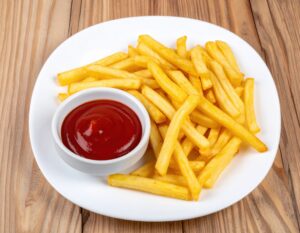 白い皿に盛られたフライドポテトと白い器のケチャップ