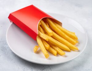 白い皿に盛られた赤いパッケージ入りフライドポテト