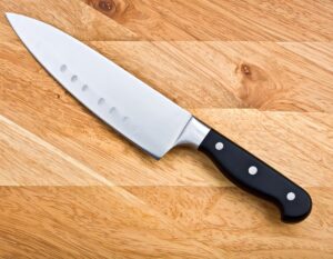 木製カッティングボードの上に置かれたシェフナイフ