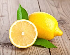 木製テーブルに置かれたカットレモンと丸ごとのレモン