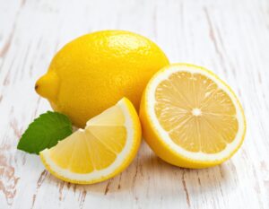 白木のテーブルに置かれたカットレモンとミント