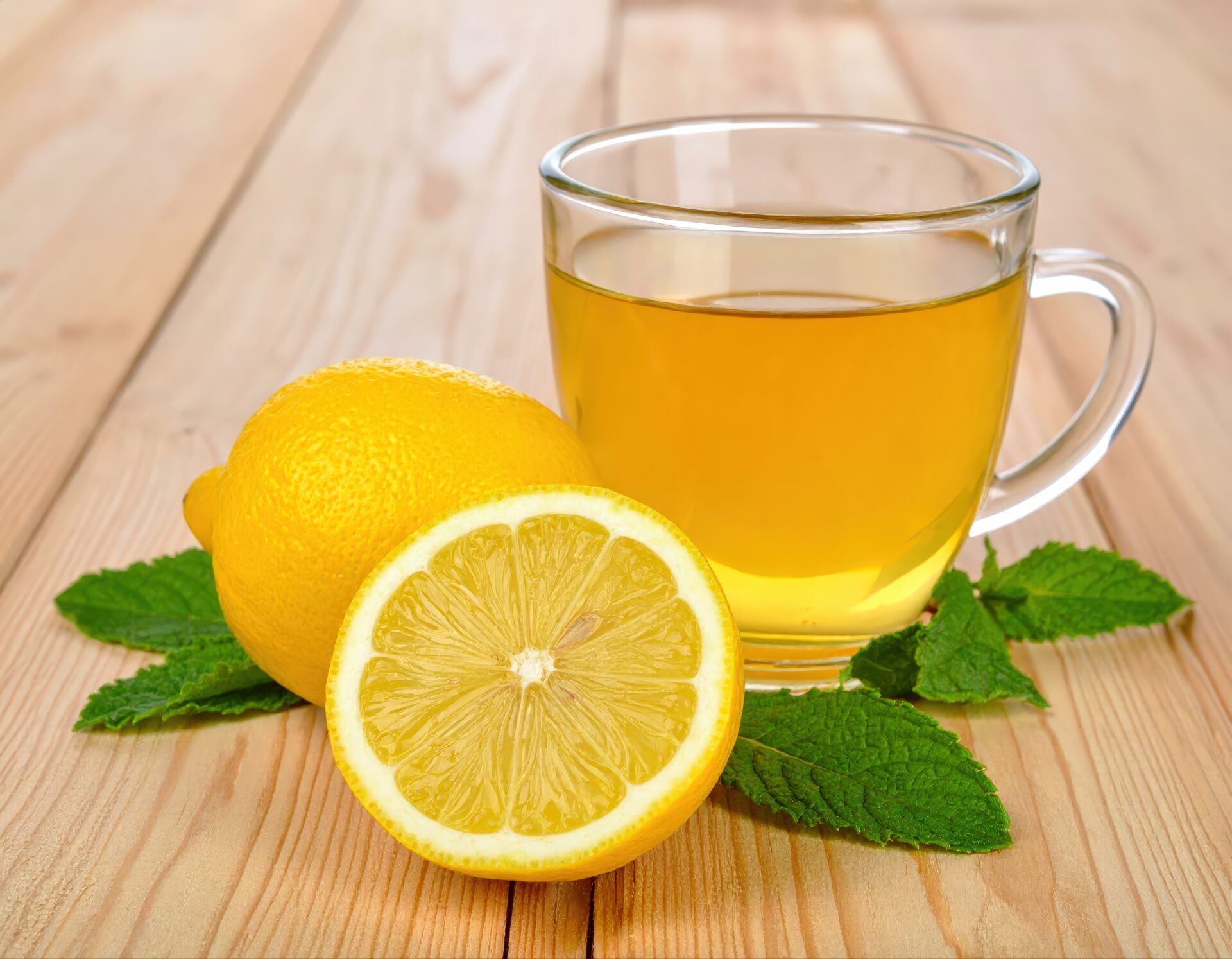 ガラスのカップのレモンティーとカットレモンとミント