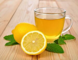 ガラスのカップのレモンティーとカットレモンとミント