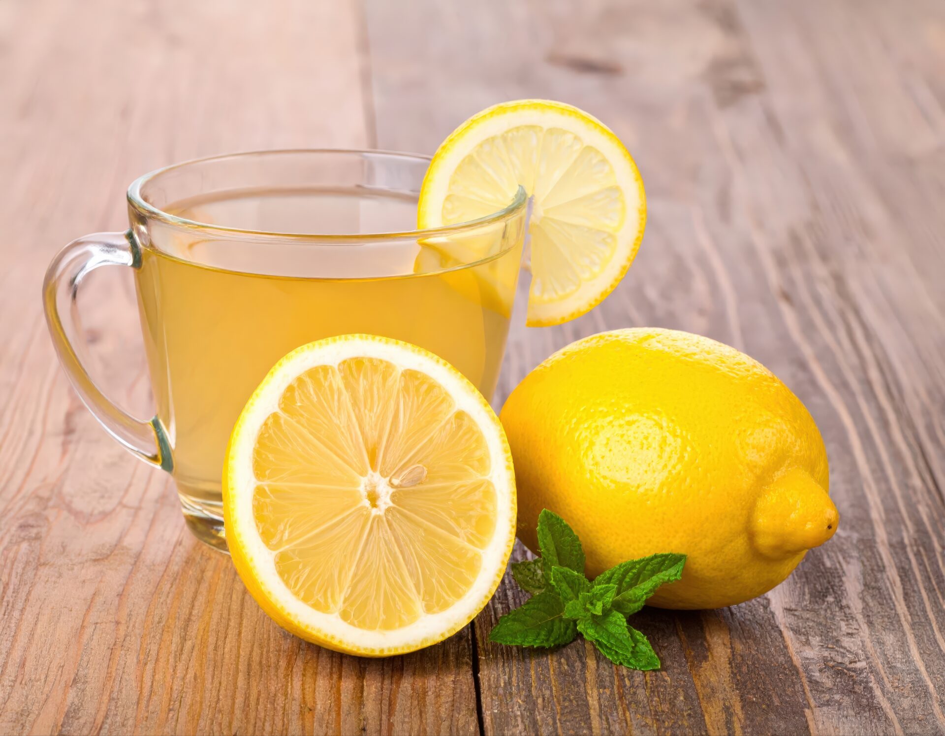 木製テーブルのガラスカップのレモンティーとレモン