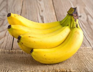 木製テーブルに置かれた房付きバナナ