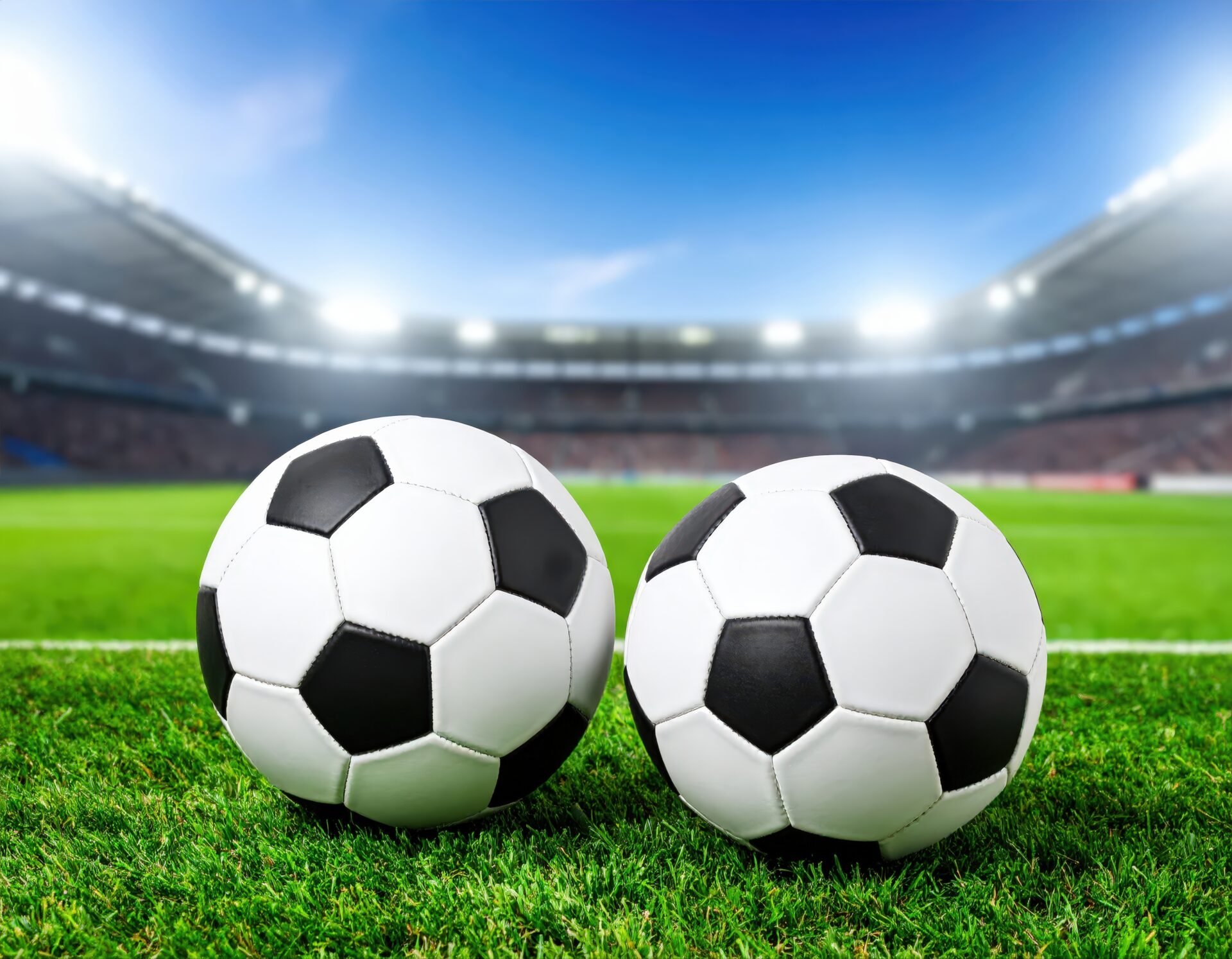 スタジアムの芝生に置かれた2つのサッカーボール