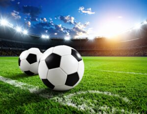 夕暮れのスタジアムに置かれた2つのサッカーボール