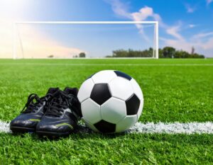 ゴール前のサッカーボールと黒いシューズ