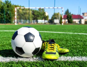 ゴール前のサッカーボールと黄色いシューズ