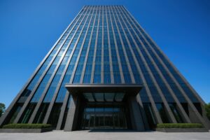 入り口が特徴的な高層オフィスビルと青空