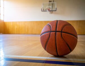 木製フロアの体育館に置かれたバスケットボール