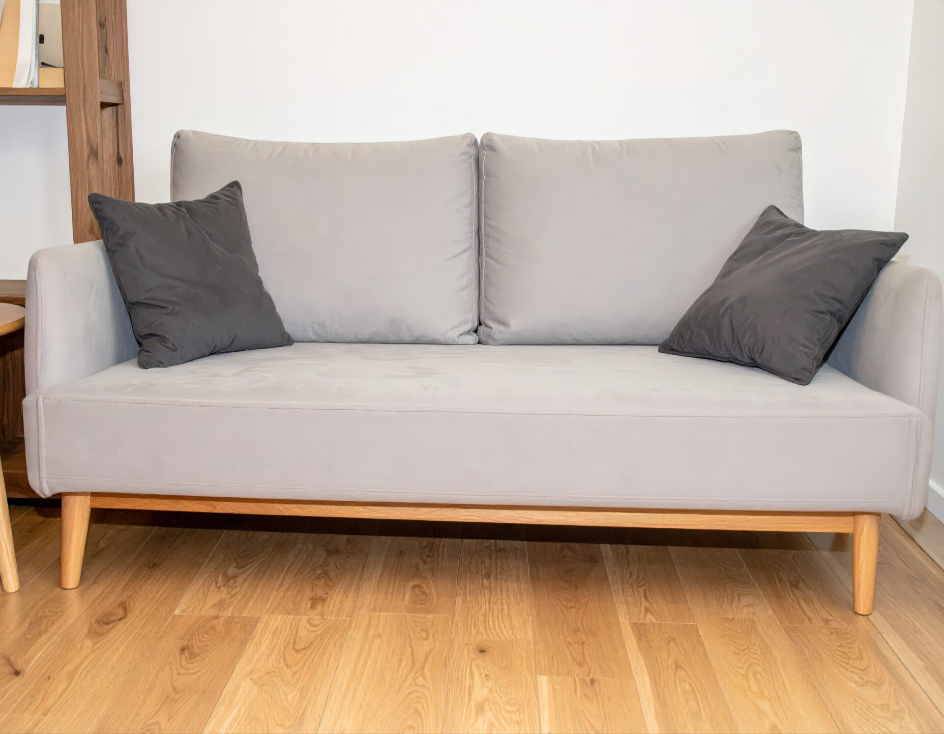 ライトグレーのソファと黒クッション