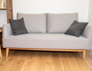 ライトグレーのソファと黒クッション