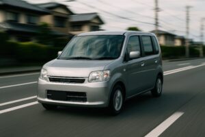 郊外の道路を走行するシルバーの軽自動車