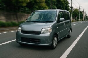 住宅街を走るグレーの軽自動車