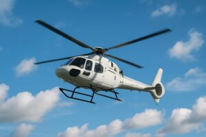 白いヘリコプターが青空をバックに上昇中