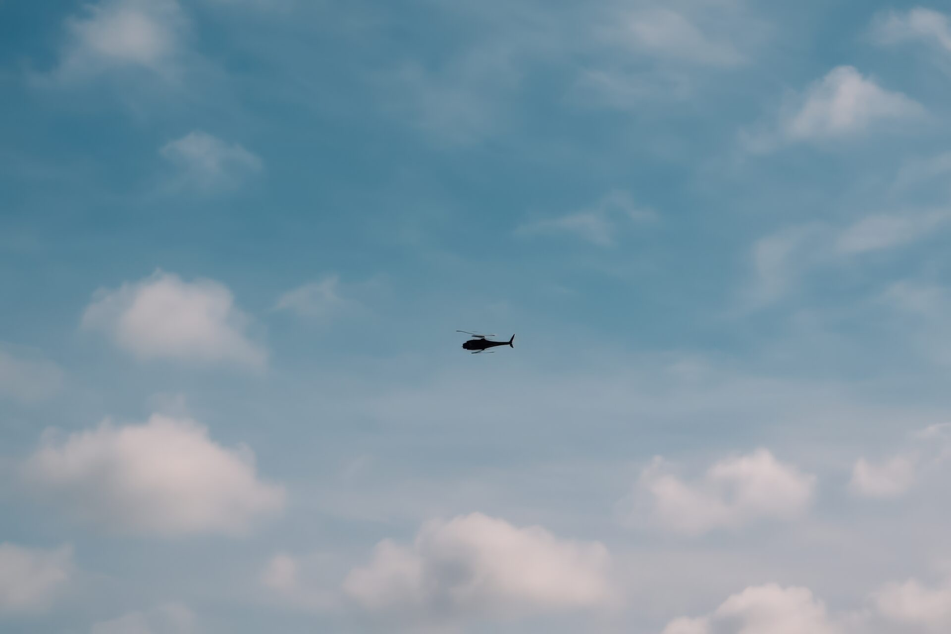 雲間を飛ぶ軍用ヘリコプターのシルエット