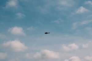 雲間を飛ぶ軍用ヘリコプターのシルエット